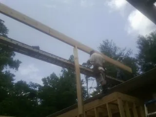Carpenter setting a ridge beam over a new addition frame — Ice Dam Removal by Roofing Brothers in Melrose